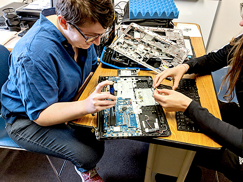 Student using tools on internal computer parts