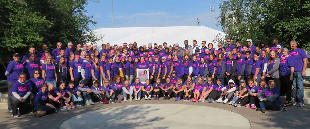 over 125 D C students, faculty, staff in purple shirts gathered for a photo