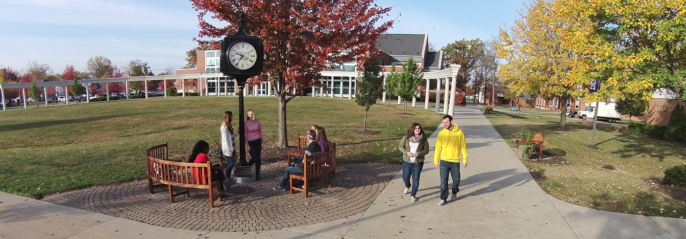 8 students walking on campus sidewalks