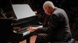 Norman Malone playing the piano on a stage