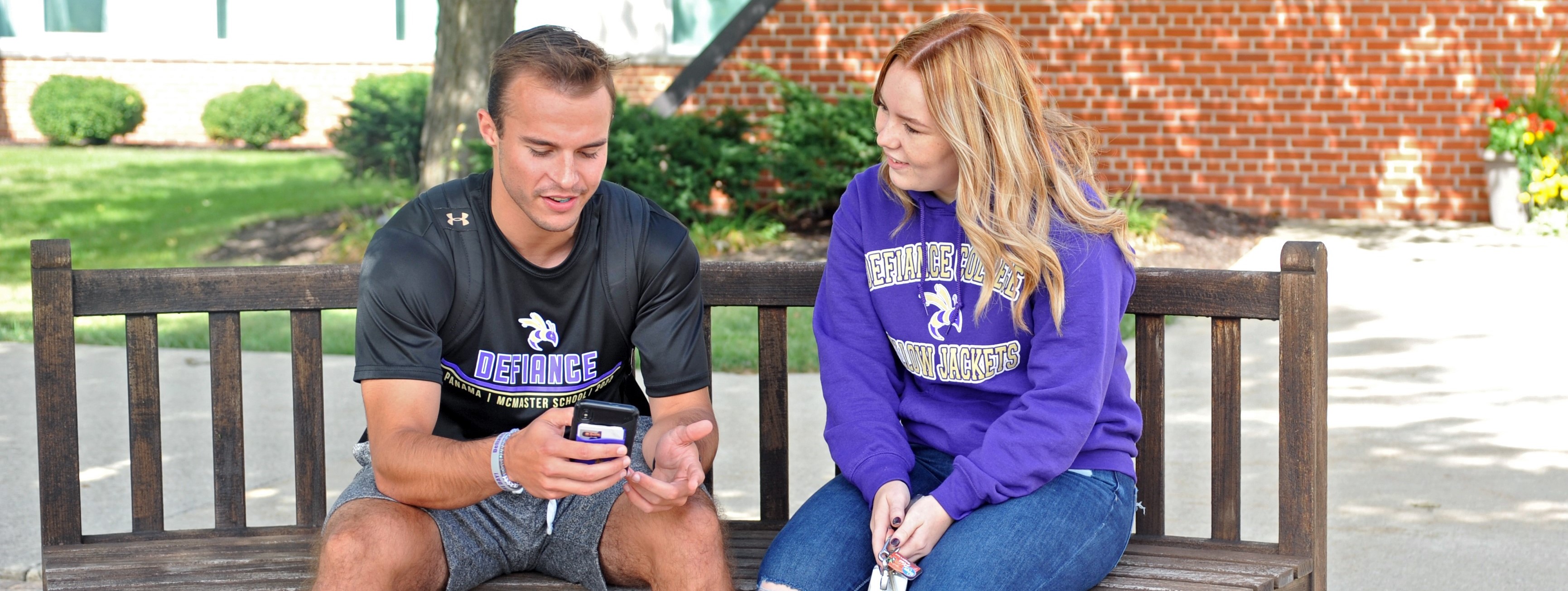 two students on a bench talking