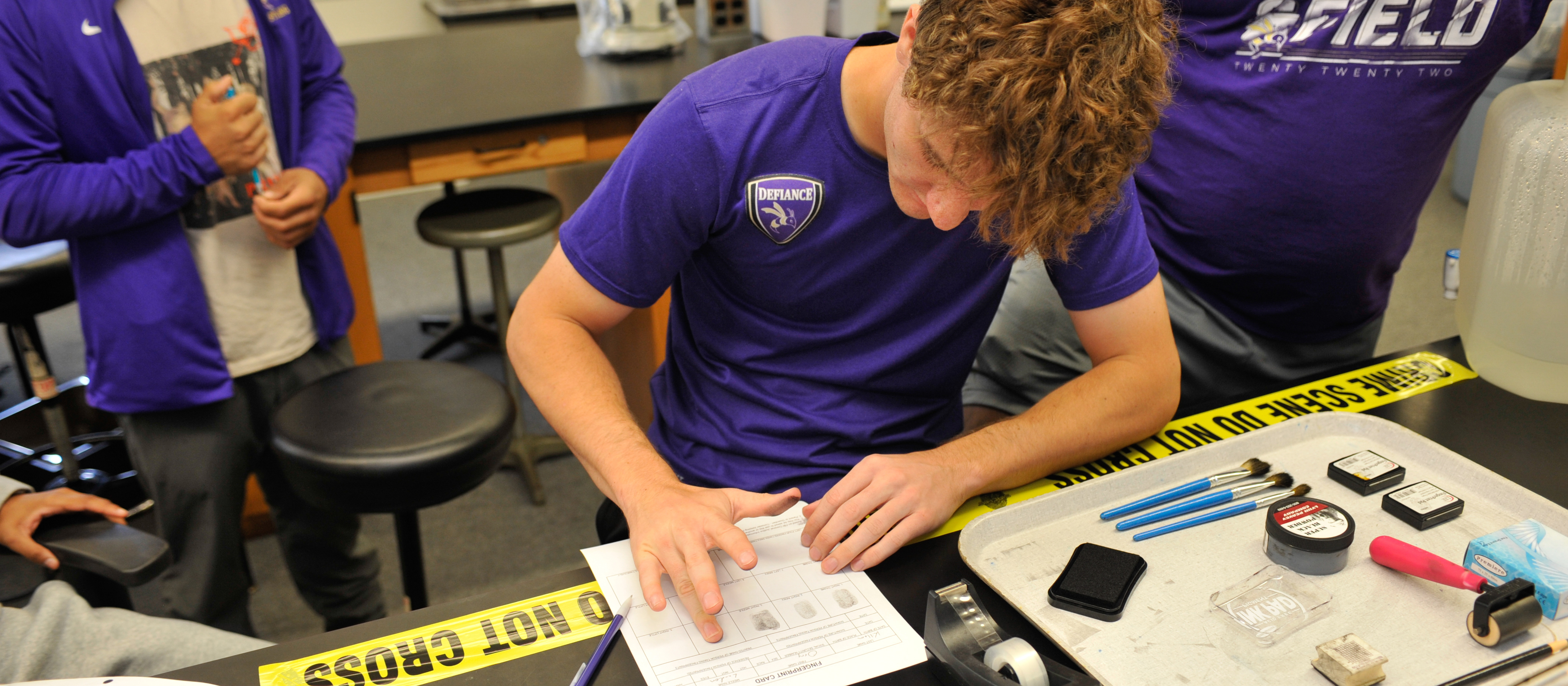 student fingerprinting himself with crime scene tape featured