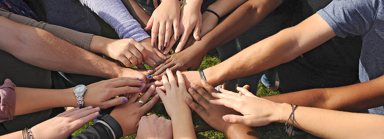 student hands coming together in a circle