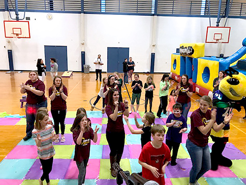 Group of students with children and their families playing games