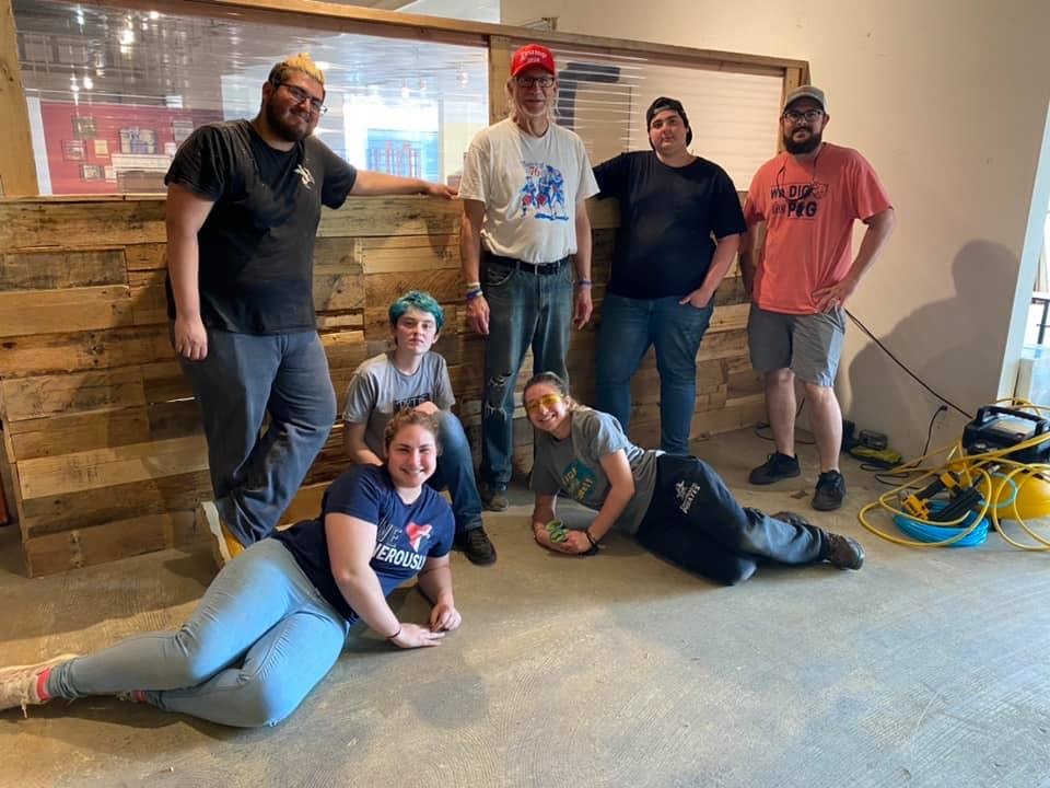 7 students posing in a work site and smiling at the camera