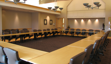 Fancy banquet set up with multiple round tables and guests seated around them.