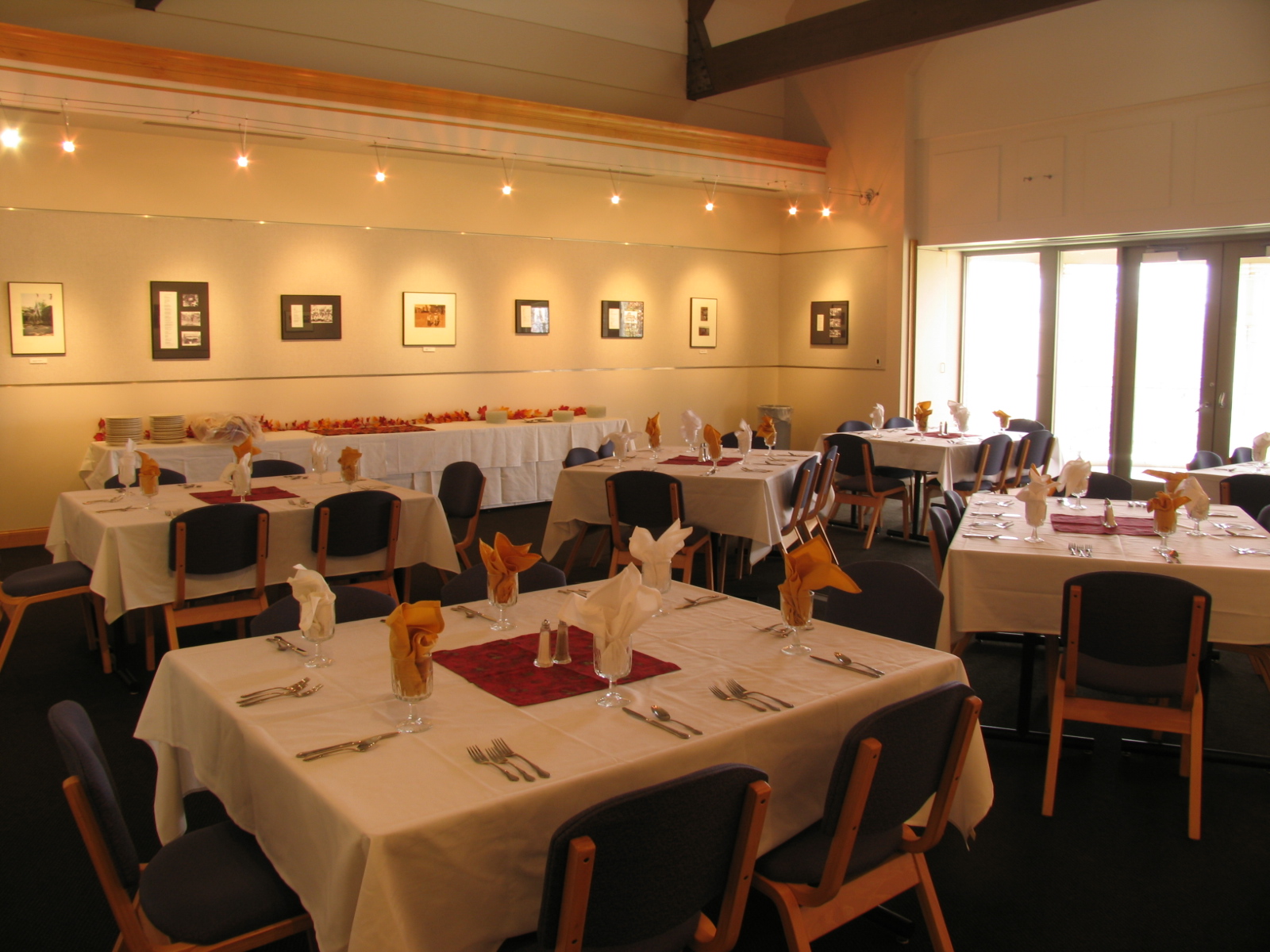 Square tables set with white linens, centerpieces, and silverware.