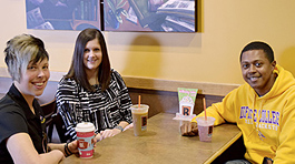 two admissions staff members with a student at a coffee house table