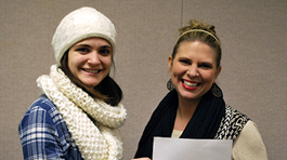 two girls smiling holding a white paper