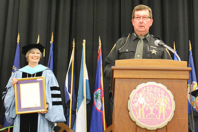 DC President Richanne C. Mankey with the silver Pilgrim Medal and Sheriff David J. Westrick speaking.