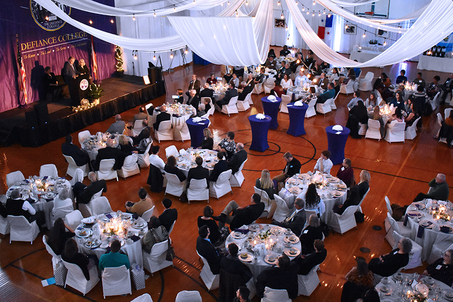 Venue photo of guests seated around 17 pictured tables draped in white