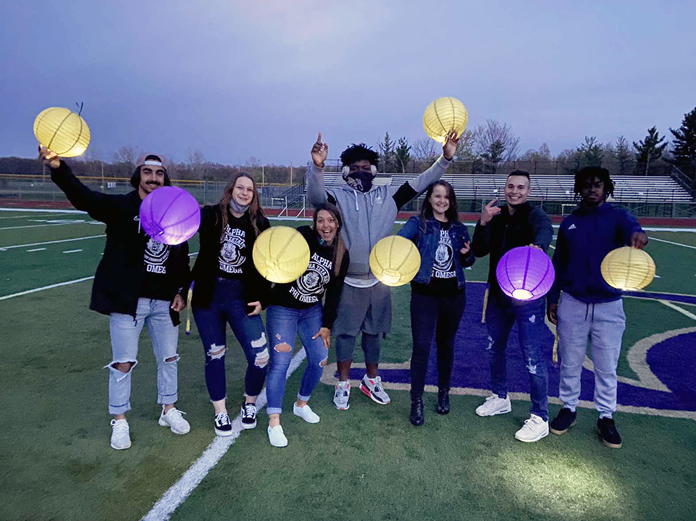 d c students holding lit paper lanterns in the dark