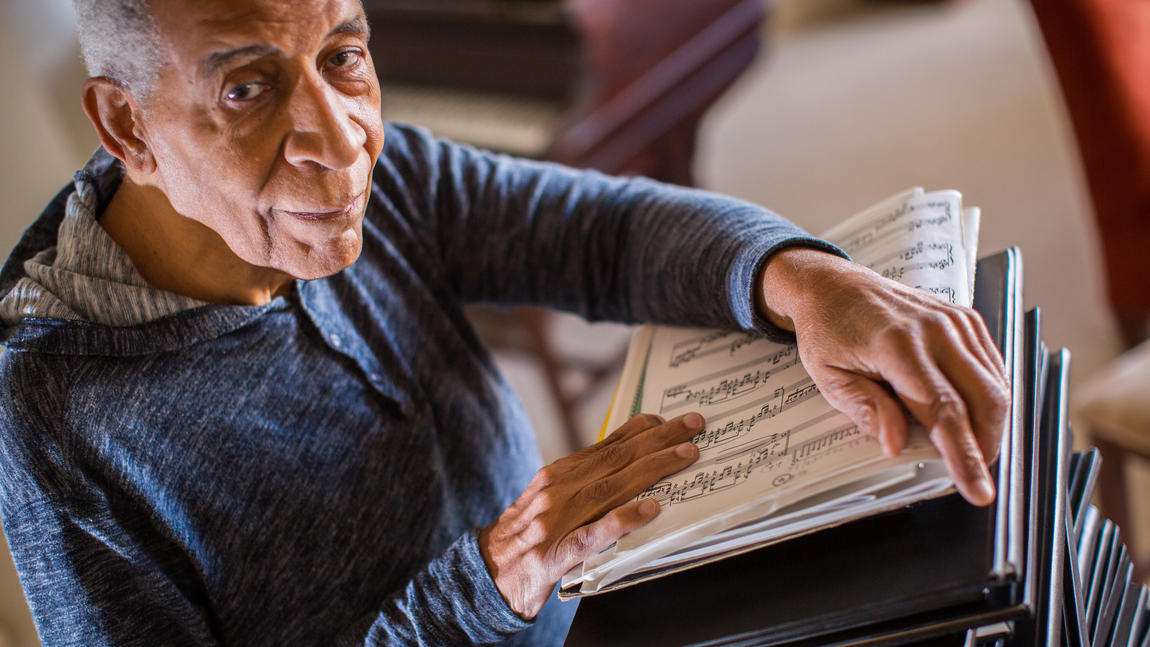 Norman Malone holding sheet music while looking at the camera