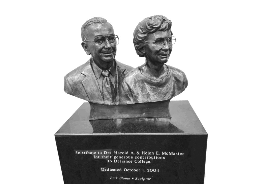 A bronze bust of Drs. Harold A. and Helen E. McMaster on a dark pedestal with an inscription honoring their contributions to Defiance College, dedicated October 1, 2004.